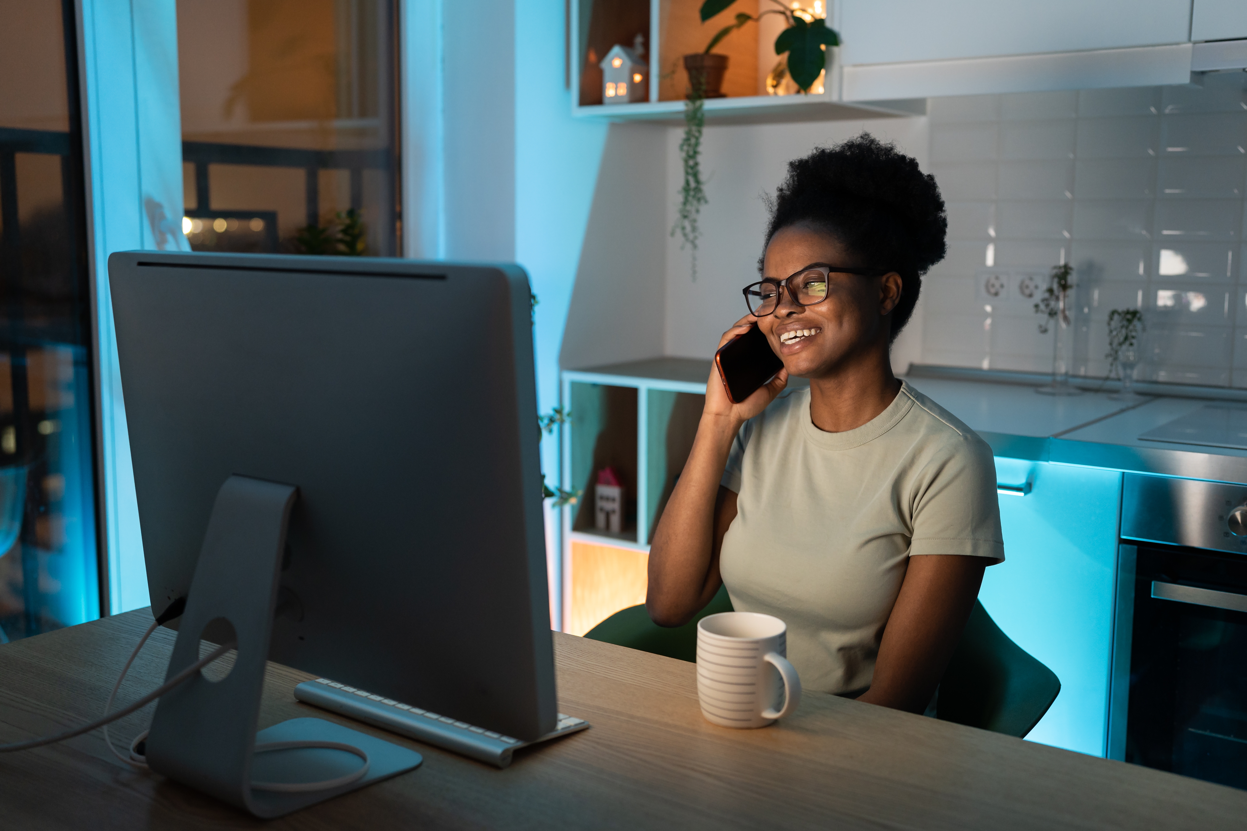 Remote black female developer chatting on smartphone, enjoying flexible freelance schedule